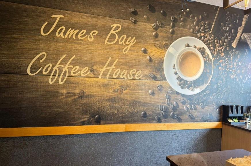The wall inside the café, painted with the words James Bay Coffee House and a cup of coffee among coffee beans